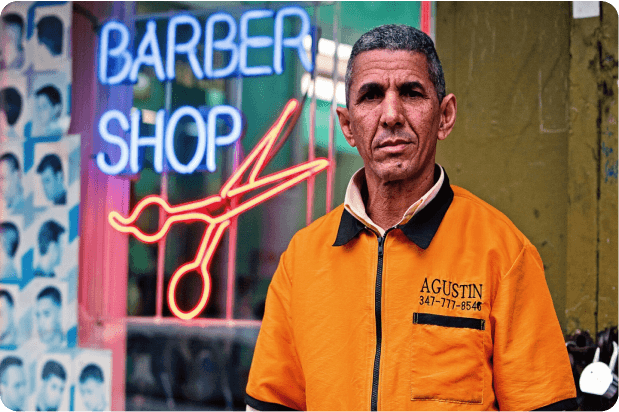 Immigrant barber in front of his shop