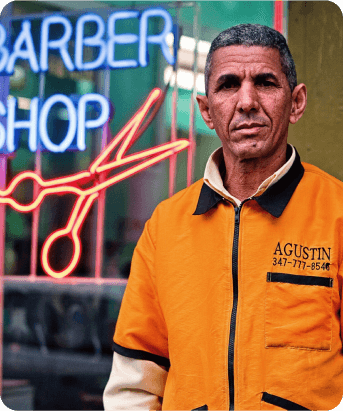 Immigrant barber in front of his shop